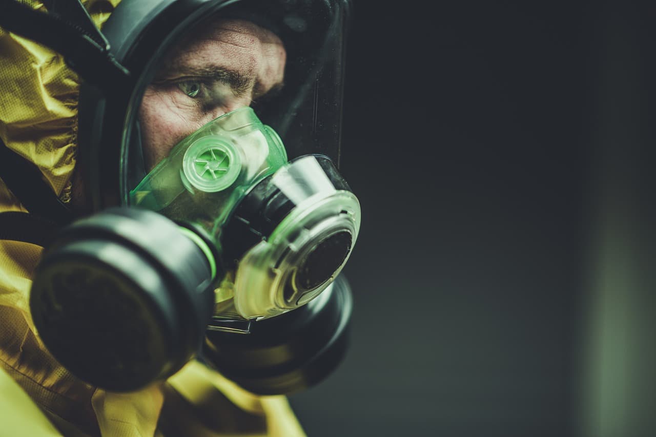 Worker in a yellow protective suit and full-face respirator