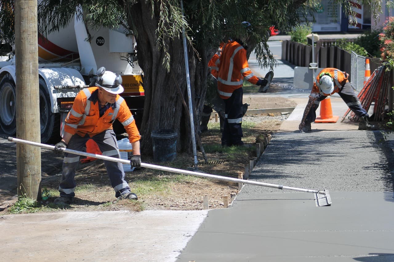 Crew finishing a fresh concrete sidewalk